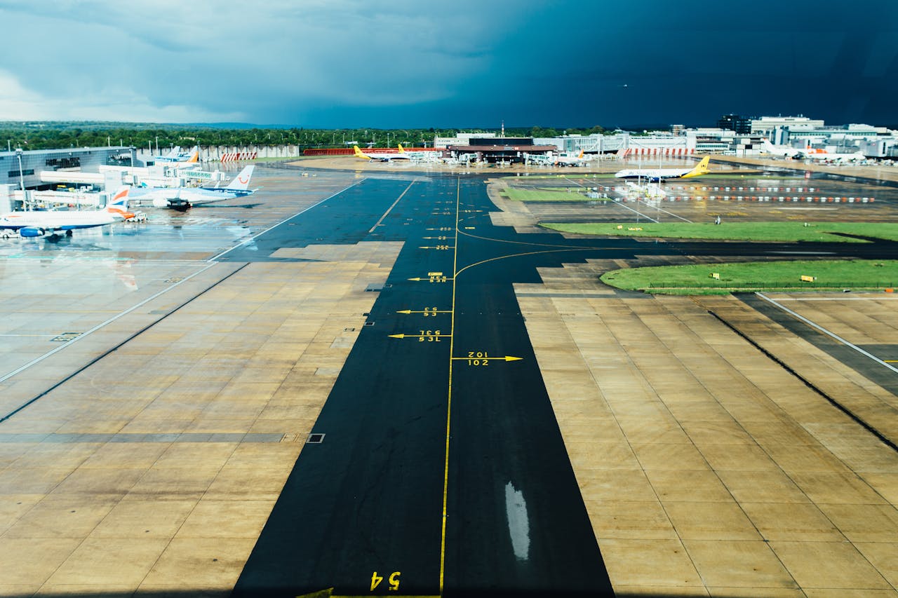 services-03 Aerial view of an airport runway with several parked planes on a cloudy day. Ideal for travel and aviation themes.